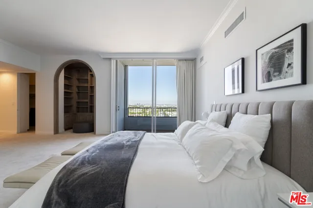 a spacious bedroom with a bed and a view of walk in closet