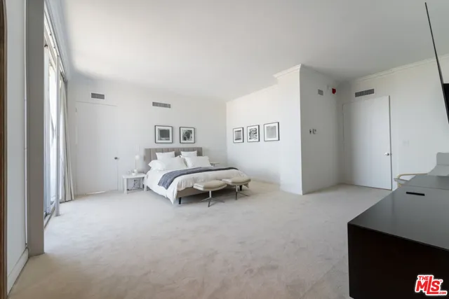 a bedroom with a bed and a large window