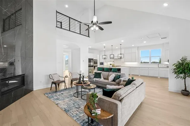 a living room with furniture kitchen view and a chandelier