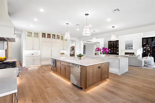 a large kitchen with stainless steel appliances a lot of counter space and wooden floor