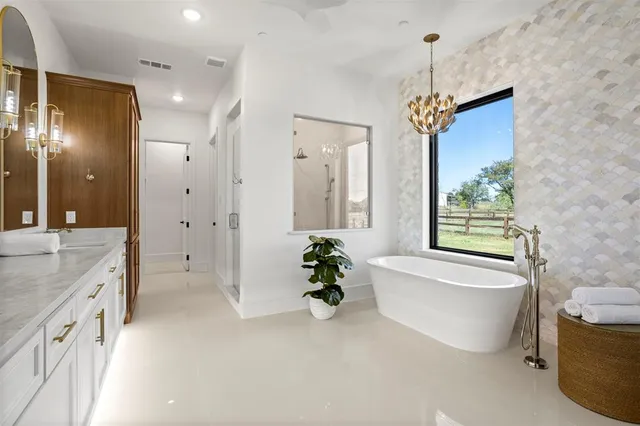 a bathroom with a tub sink and mirror
