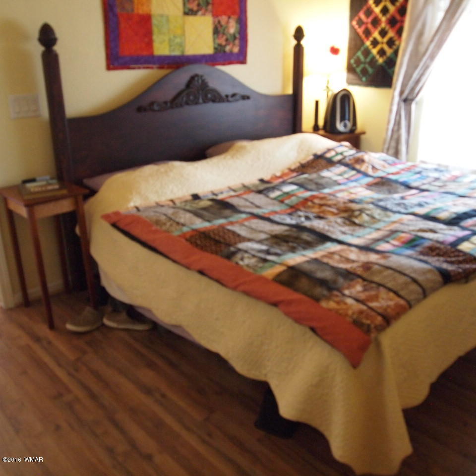 4214 Indian Bend Road Snowflake, AZ 85937 - Photo 21 of 43 a bedroom with a bed and wooden floor