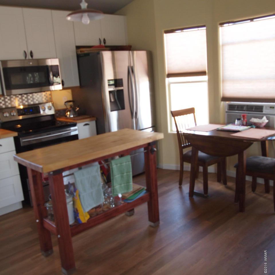 4214 Indian Bend Road Snowflake, AZ 85937 - Photo 7 of 43 a kitchen with stainless steel appliances a table chairs and a refrigerator