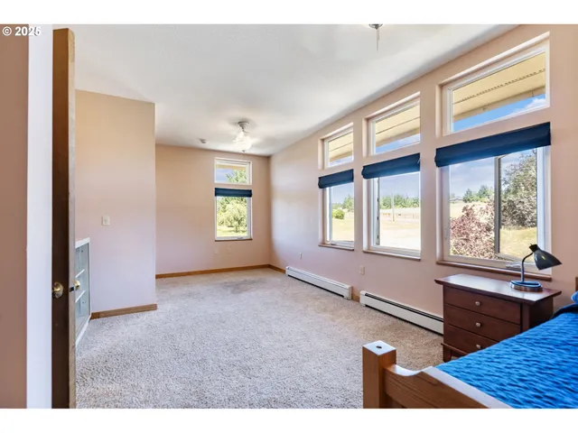 a view of an empty room with window and a kitchen