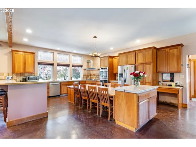 a kitchen with stainless steel appliances kitchen island granite countertop wooden cabinets and dining table