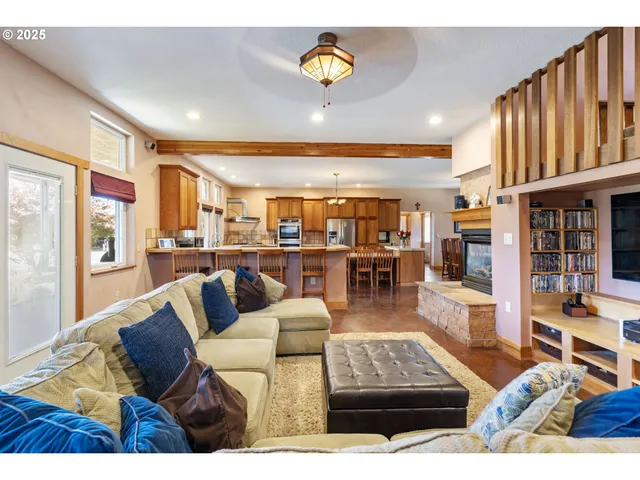 a living room with couches and a view of kitchen with dining table