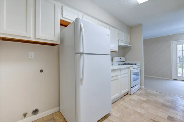 a kitchen with white cabinets and white appliances