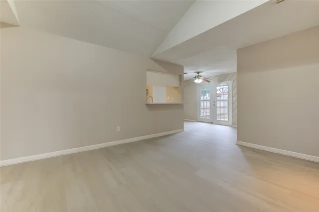 a view of a big room with wooden floor and windows