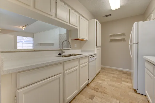 a kitchen with cabinets and a refrigerator