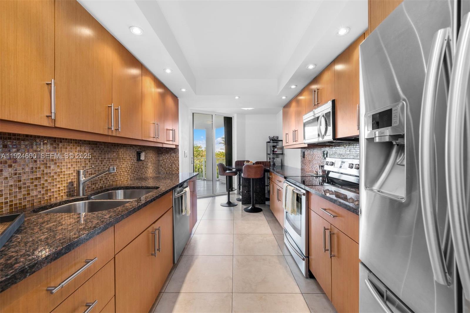 4000 Towerside Terrace, Unit 705 Miami, FL 33138 - Photo 15 of 42 a kitchen with stainless steel appliances granite countertop a refrigerator a sink dishwasher a stove and a microwave oven