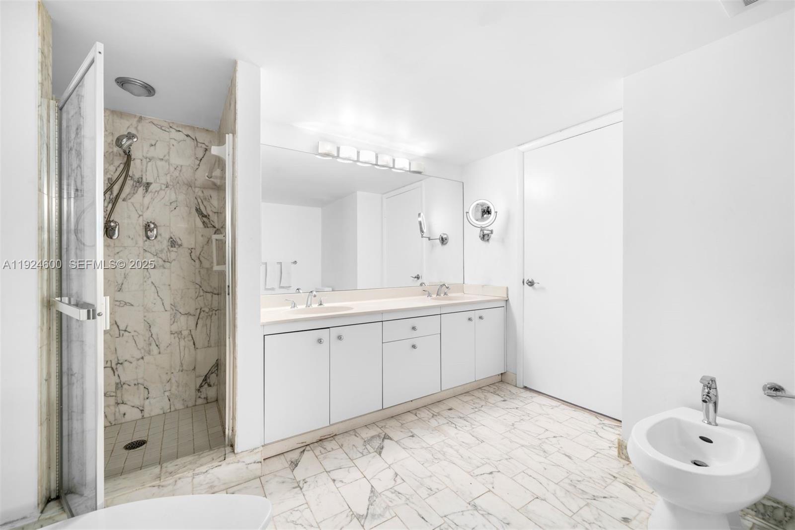 4000 Towerside Terrace, Unit 705 Miami, FL 33138 - Photo 23 of 42 a spacious bathroom with a shower sink and mirror