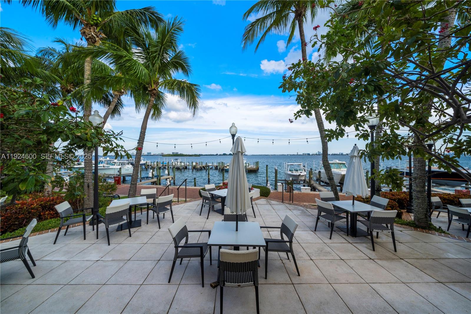 4000 Towerside Terrace, Unit 705 Miami, FL 33138 - Photo 34 of 42 a view of a patio with table and chairs potted plants and palm tree