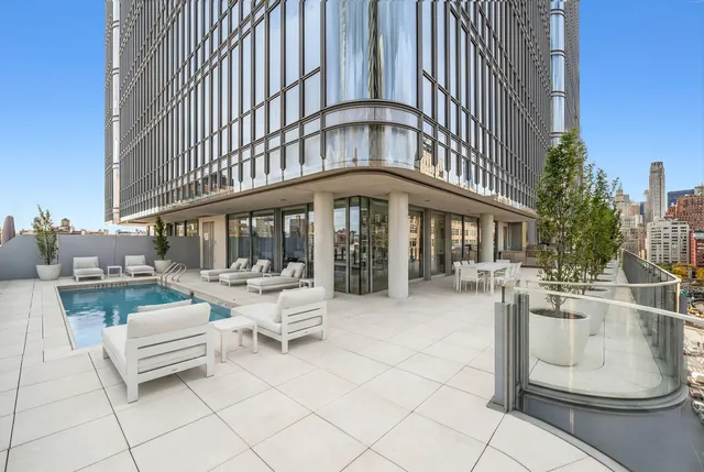 a living room with furniture floor to ceiling window and wooden floor
