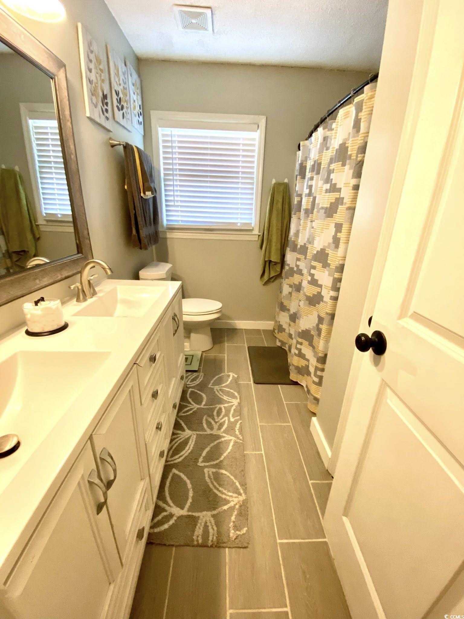512 South Hazel Avenue Andrews, SC 29510 - Photo 8 of 15 Bathroom with double vanity and a shower with curt