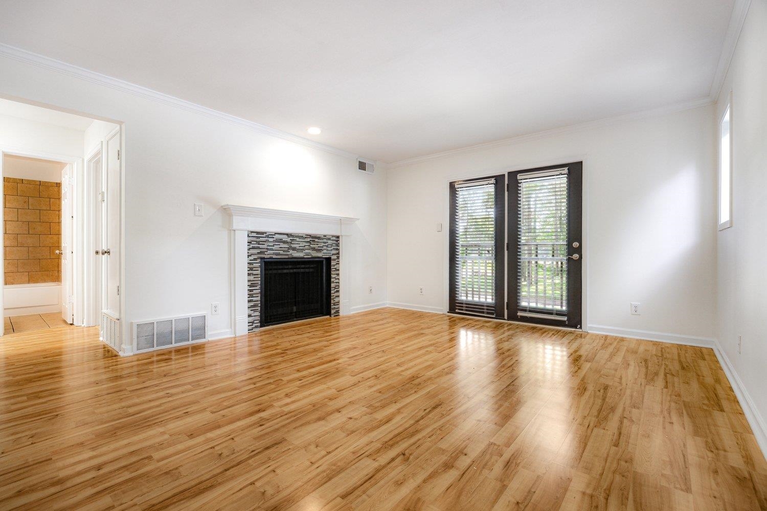 1847 Gray Ridge Cove, Unit 2 Germantown, TN 38138 - Photo 11 of 24 Unfurnished living room featuring light wood-type flooring, ornamental molding, a fireplace, and baseboards