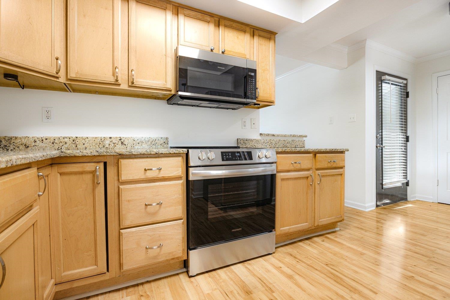 1847 Gray Ridge Cove, Unit 2 Germantown, TN 38138 - Photo 6 of 24 Kitchen with stainless steel appliances, ornamental molding, light wood-style flooring, light brown cabinetry, and baseboards
