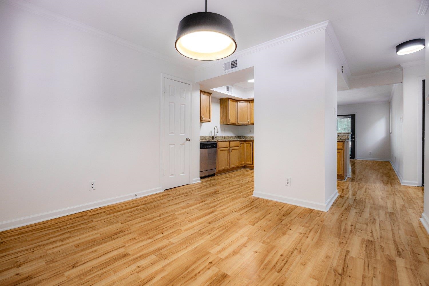 1847 Gray Ridge Cove, Unit 2 Germantown, TN 38138 - Photo 9 of 24 Unfurnished living room with light wood finished floors, crown molding, baseboards, and a sink