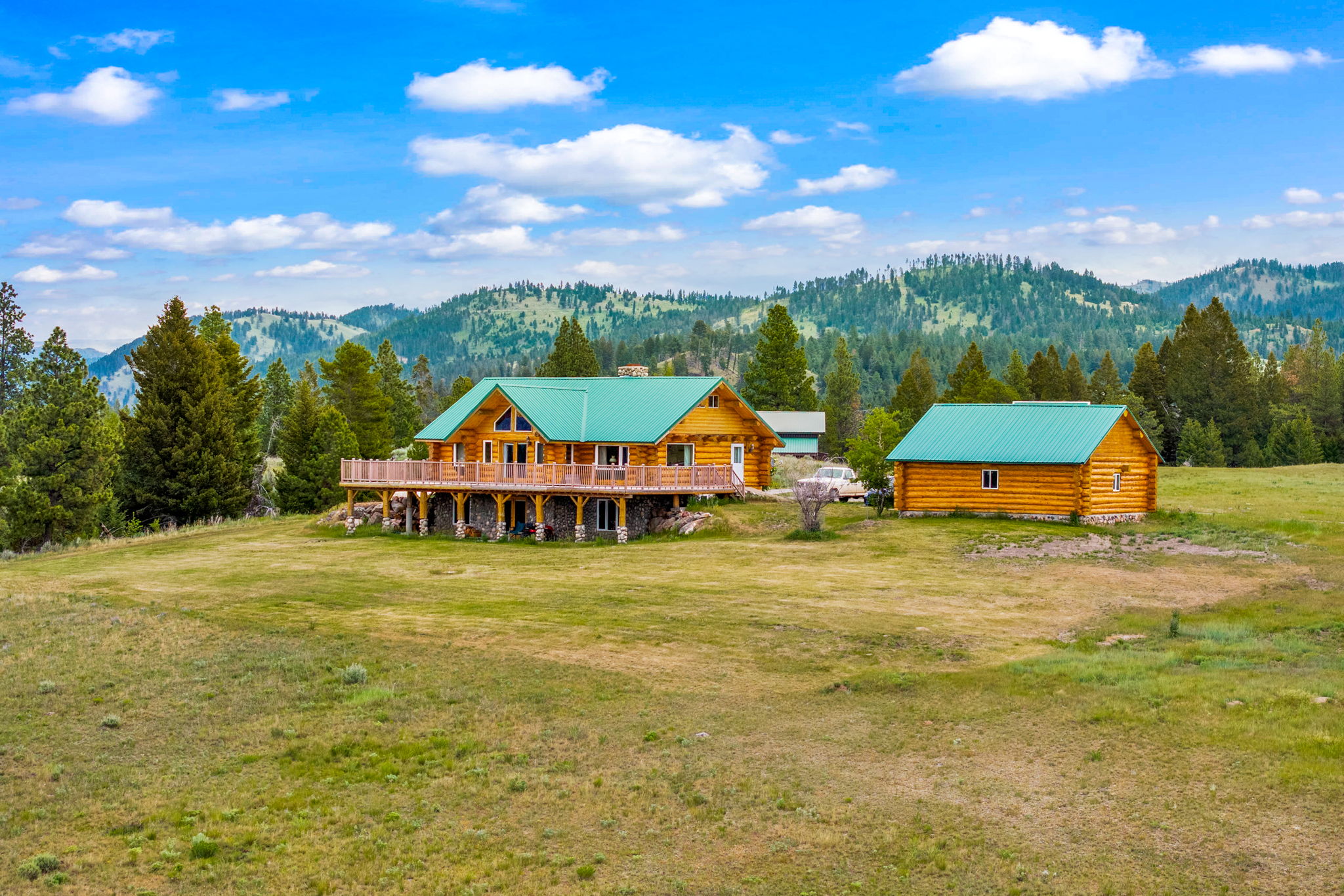 3358 Strandskov Road Lincoln, MT 59639 - Photo 57 of 80 Back of house with log exterior, a yard, and a wooded view