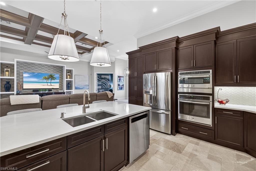 7405 Acorn Way Naples, FL 34119 - Photo 50 of 50 a kitchen with stainless steel appliances a sink a stove a refrigerator and cabinets