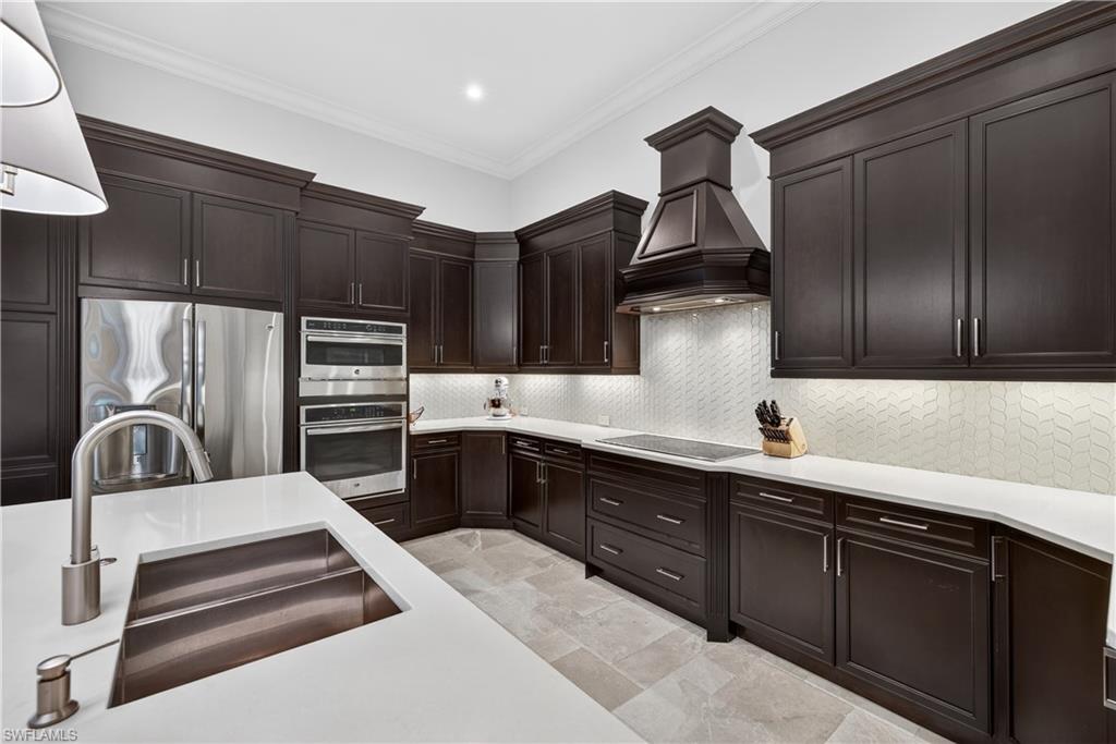 7405 Acorn Way Naples, FL 34119 - Photo 14 of 50 a kitchen with sink cabinets and stainless steel appliances
