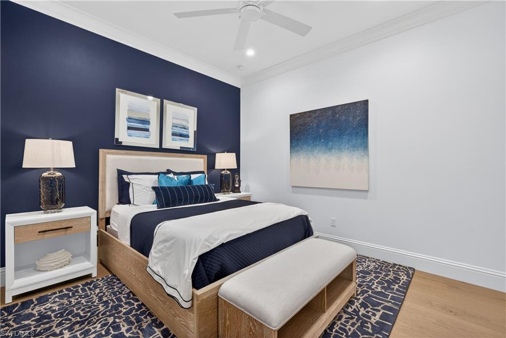 7405 Acorn Way Naples, FL 34119 - Photo 21 of 50 a bedroom with a large bed and a lamp