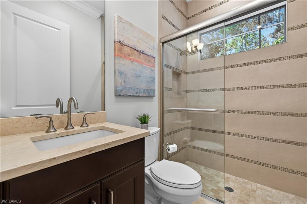 7405 Acorn Way Naples, FL 34119 - Photo 23 of 50 a bathroom with a sink a toilet a mirror and shower
