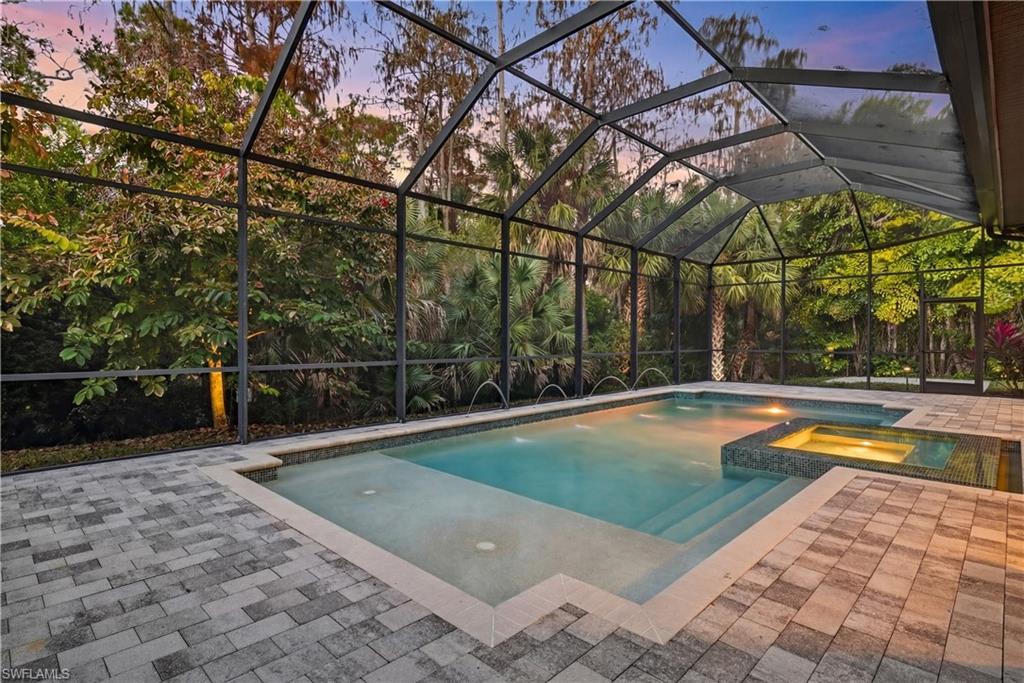 7405 Acorn Way Naples, FL 34119 - Photo 36 of 50 Expansive Screened Lanai with Heated Saltwater Pool and Spa with Decorative Waterfall Features, Offering Tranquil Preserve Privacy, and Upgraded Nightscape Lighting