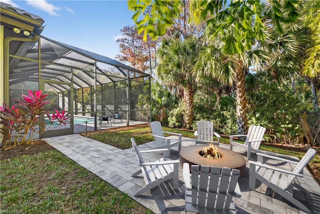 7405 Acorn Way Naples, FL 34119 - Photo 38 of 50 a view of a patio with table and chairs potted plants and large tree