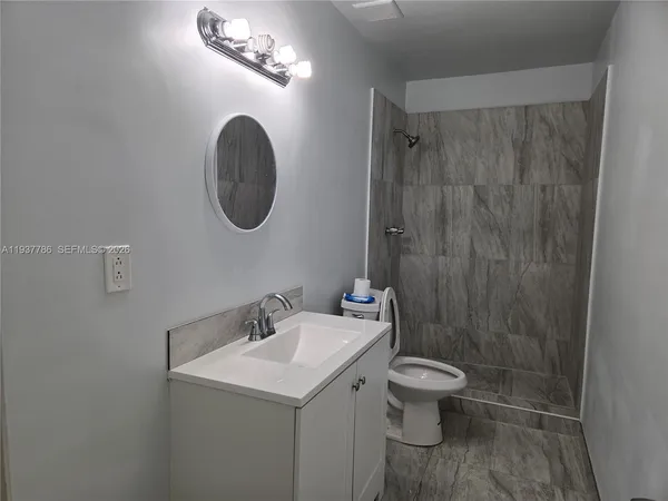 a bathroom with a toilet a sink and a mirror