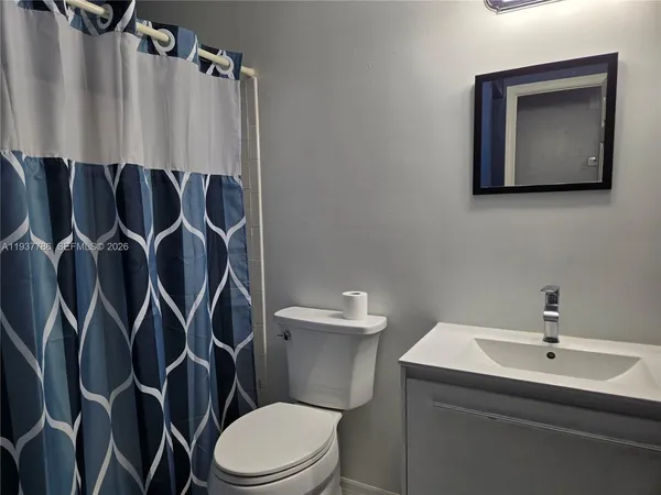 a bathroom with a toilet sink and mirror