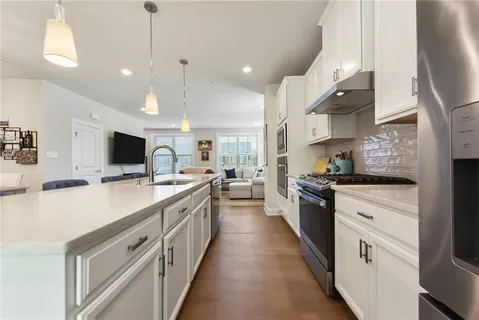 a large kitchen with stainless steel appliances kitchen island a large counter tops and a stove