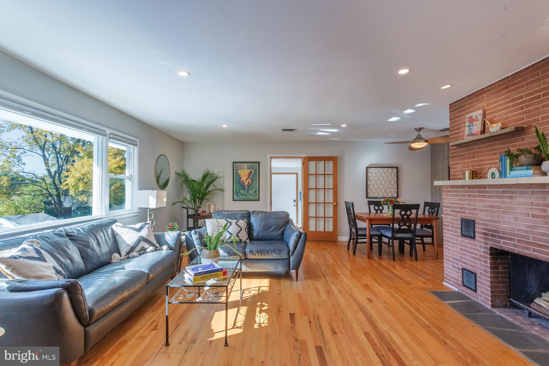 2017 Quarry Road Yardley, PA 19067 - Photo 9 of 37 a living room with furniture a fireplace and a dining table with wooden floor