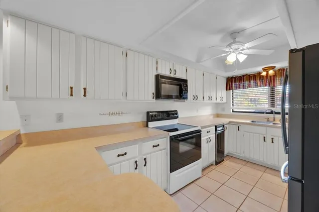 a kitchen with granite countertop white cabinets white stainless steel appliances with a sink and dishwasher