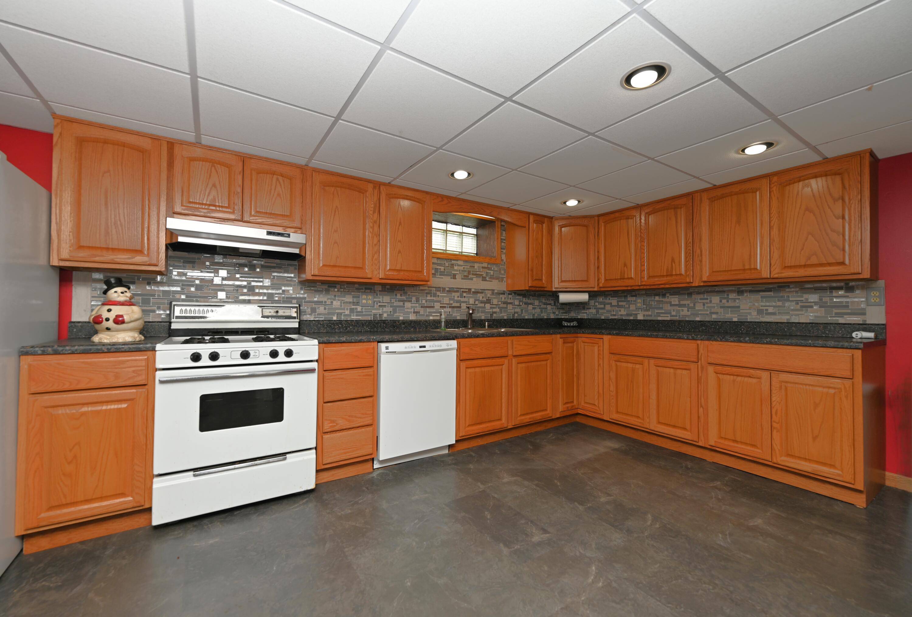 5110 West 400 North Winamac, IN 46996 - Photo 33 of 35 a kitchen with granite countertop wooden cabinets and white appliances