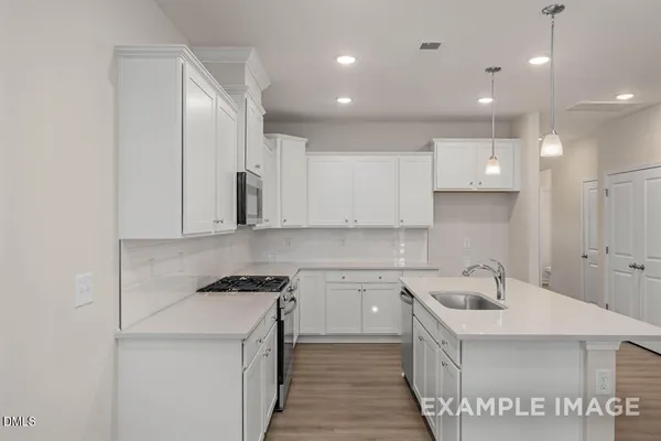 a kitchen with a sink a stove and cabinets