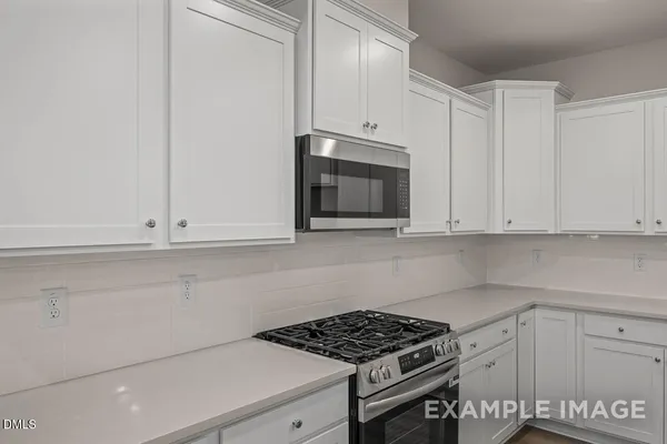 a kitchen with granite countertop white cabinets and stainless steel appliances