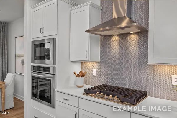 a kitchen with granite countertop a sink cabinets and wooden floor