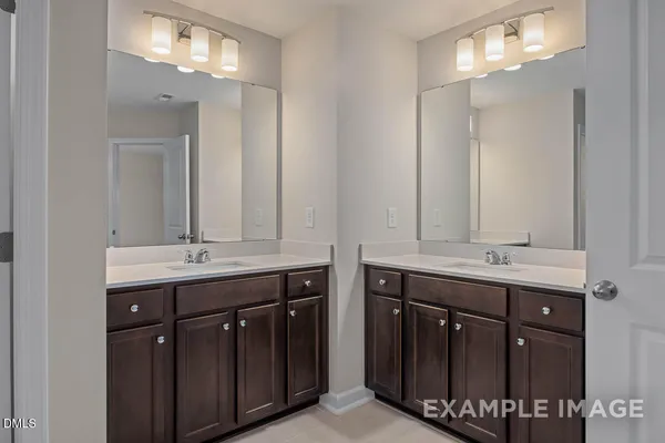 a bathroom with double sink and a mirror