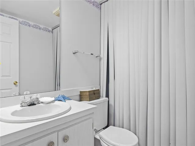 a bathroom with a sink a toilet and shower curtain