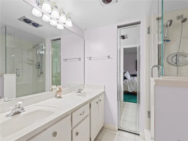 a en suite bathroom with a sink double vanity and a mirror