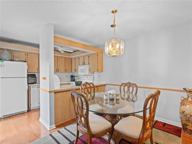 a view of a dining room with furniture a chandelier and wooden floor