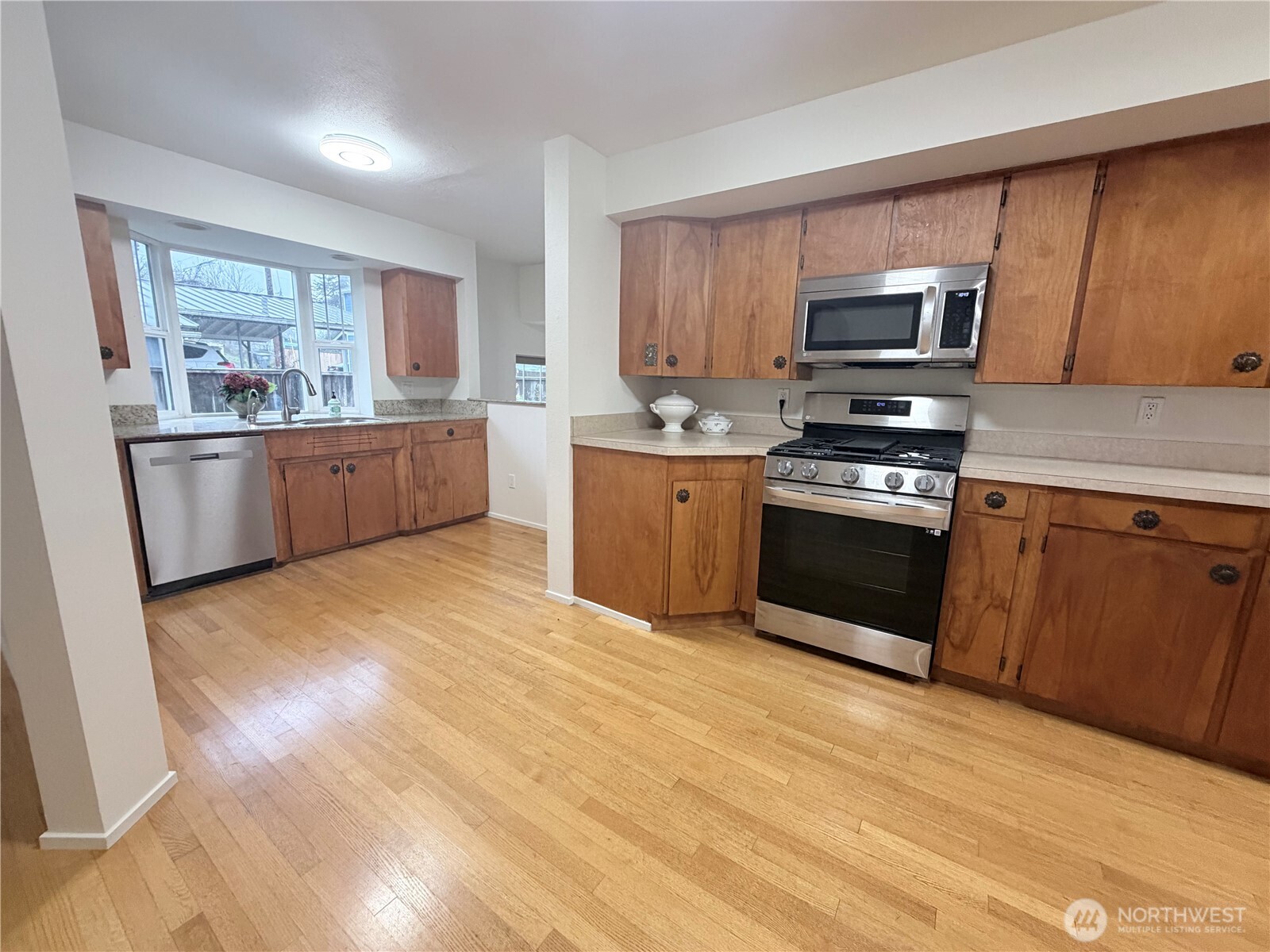 517 South 3rd Street McCleary, WA 98557 - Photo 13 of 38 a large kitchen with stainless steel appliances granite countertop a stove a sink dishwasher a microwave oven with cabinets and wooden floor