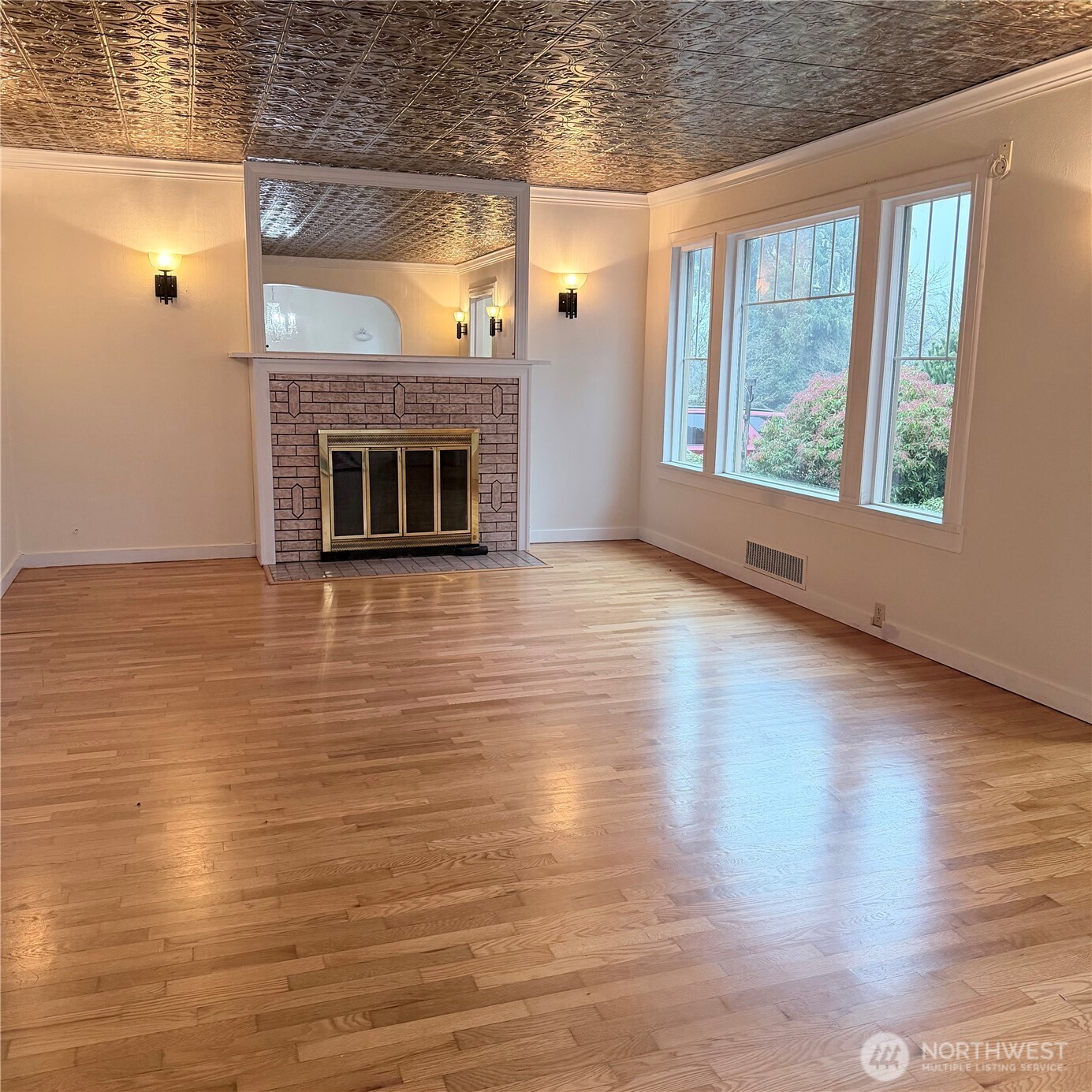 517 South 3rd Street McCleary, WA 98557 - Photo 4 of 38 an empty room with wooden floor fireplace and windows