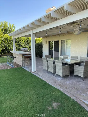 a view of a house with backyard sitting area and garden