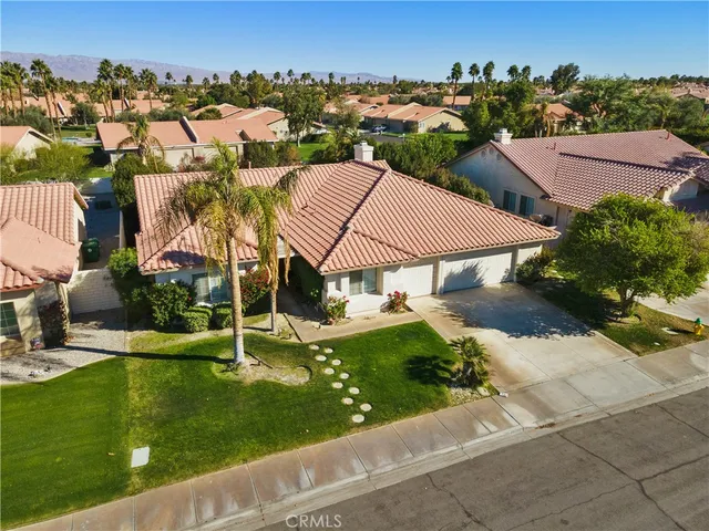an aerial view of residential houses with outdoor space and trees