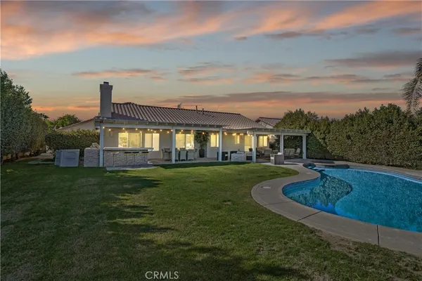 a view of a house with a big yard dining table and chairs