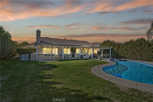 a view of a house with a big yard dining table and chairs