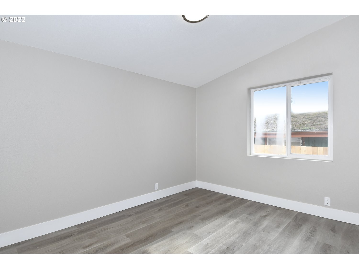 1465 Southeast Maple Loop Gresham, OR 97080 - Photo 24 of 32 a view of an empty room with wooden floor and a window