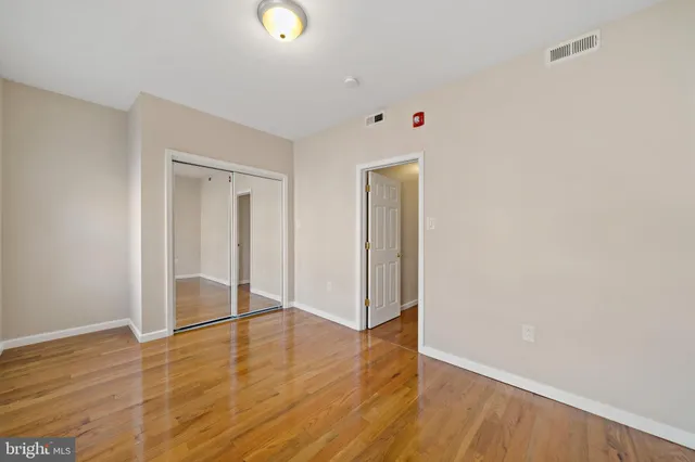 a view of an empty room with wooden floor