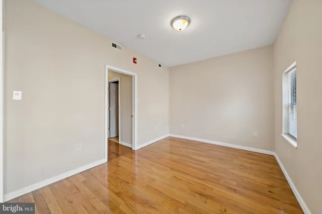 an empty room with wooden floor and closet
